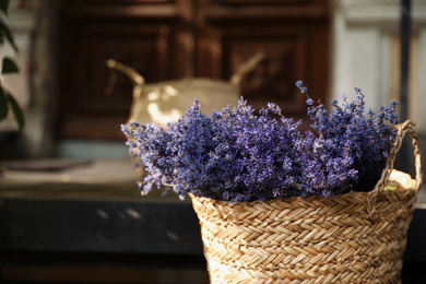 Photo of Wicker basket with beautiful lavender flowers outdoors, closeup