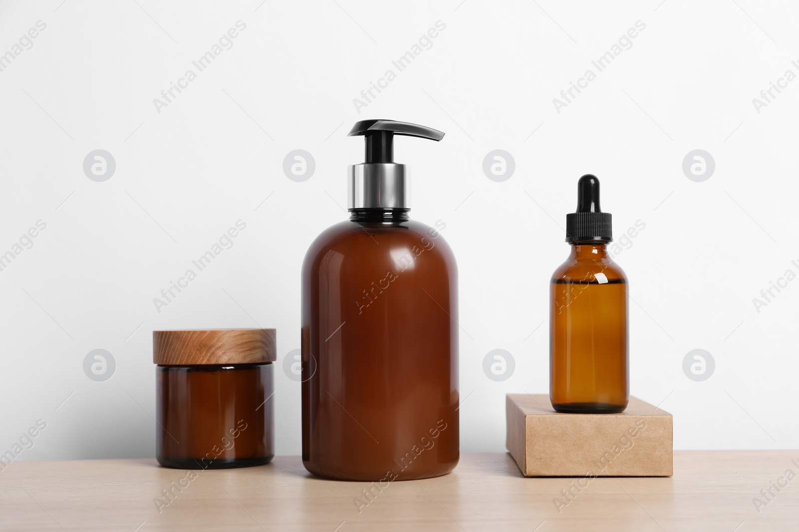 Photo of Bottles with different cosmetic products on wooden table