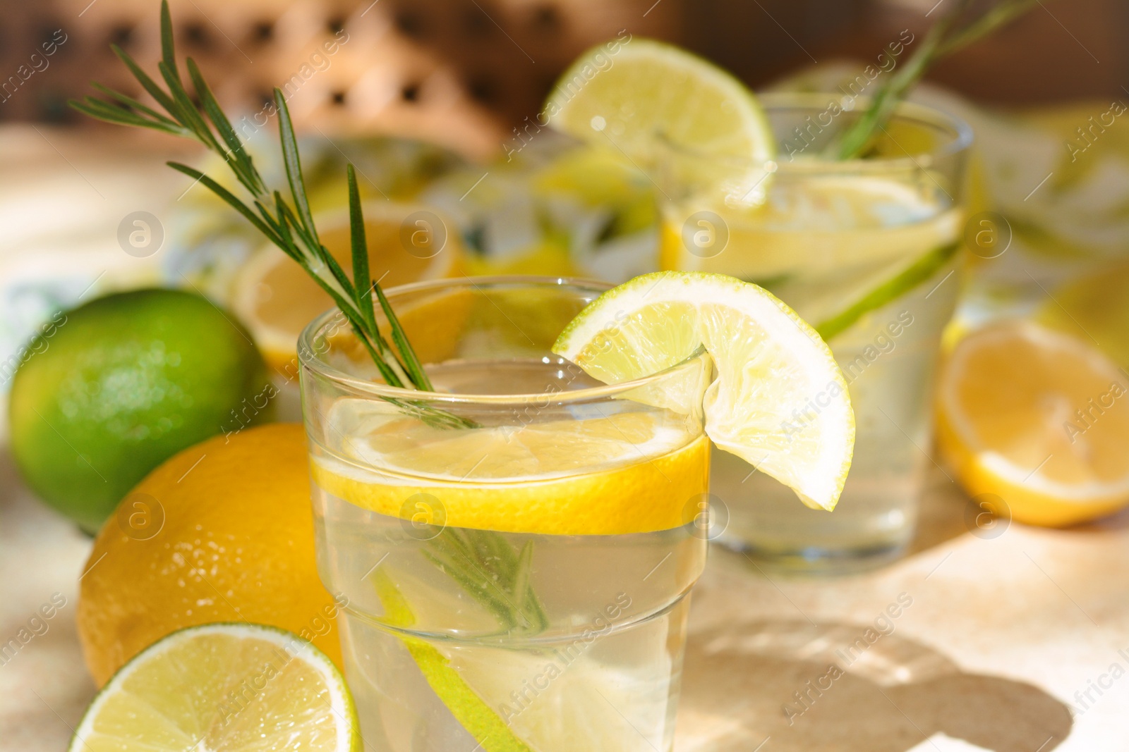 Photo of Tasty summer refreshing lemonade and ingredients on light table, closeup