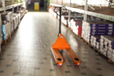 Blurred view of manual pallet truck in wholesale warehouse