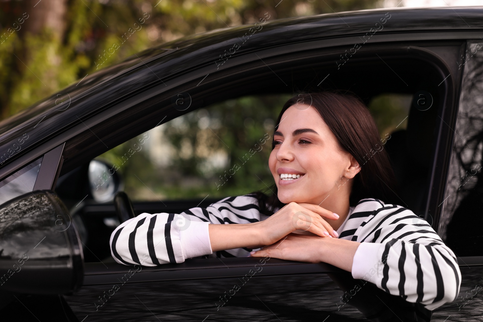 Photo of Young woman sitting inside her modern car