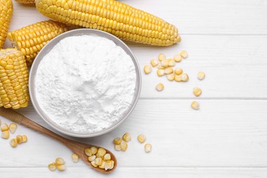 Photo of Bowl with corn starch, ripe cobs and kernels on white wooden table, flat lay. Space for text