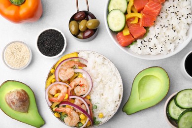 Photo of Poke bowls and ingredients on white table, flat lay