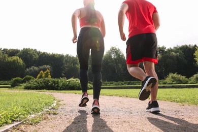 Photo of Healthy lifestyle. Couple running in park on sunny day, closeup