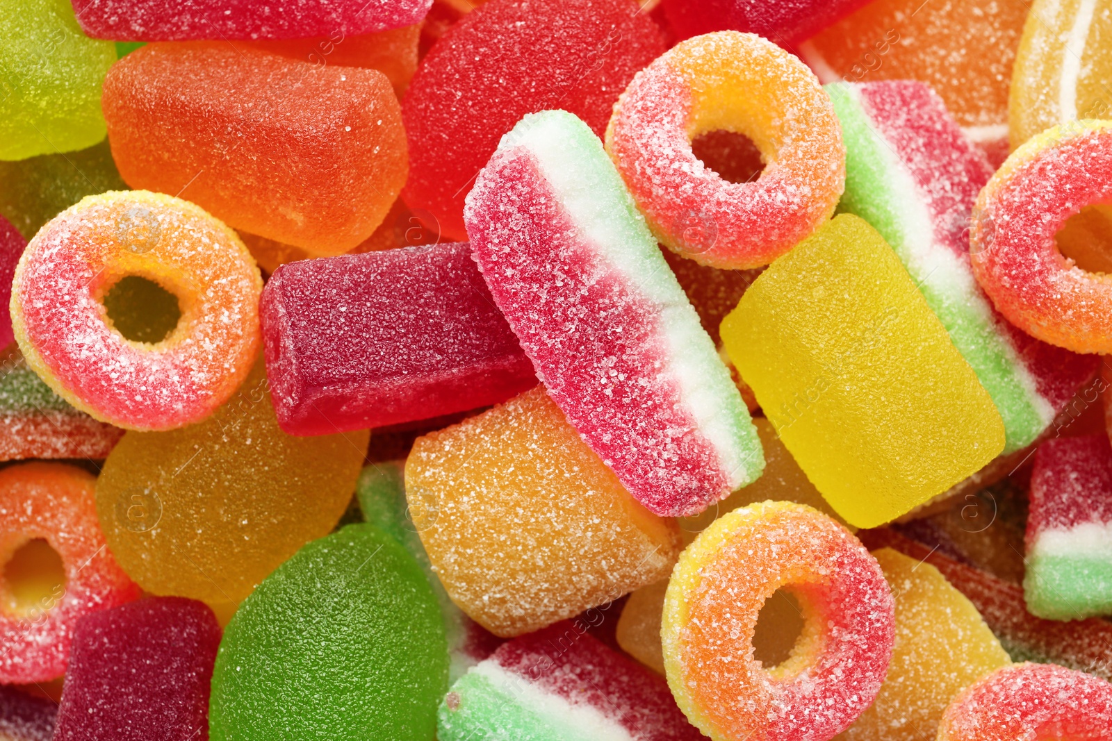 Photo of Different tasty jelly candies as background, top view