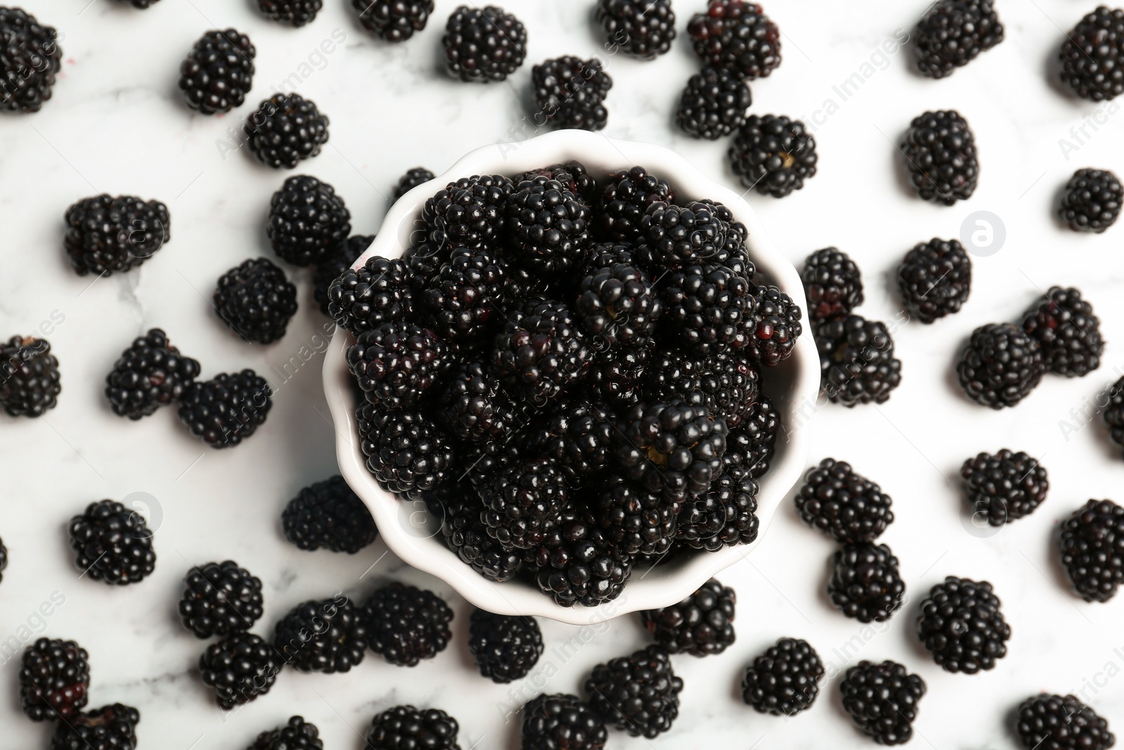 Photo of Flat lay composition with bowl of fresh blackberry on light background