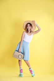 Photo of Young woman with roller skates and retro radio on color background