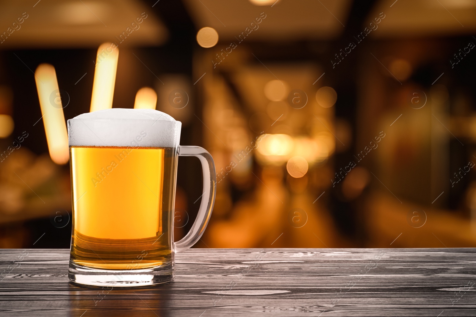 Image of Fresh cold beer on wooden table in pub, space for text