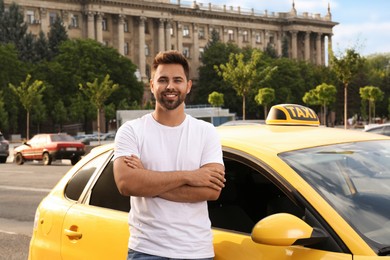 Photo of Handsome taxi driver near car on city street