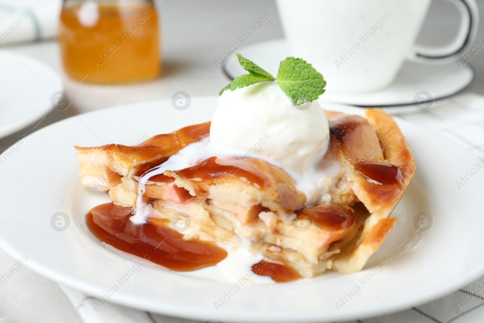 Photo of Slice of traditional apple pie with ice cream on plate, closeup