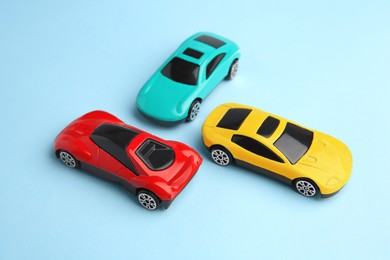 Photo of Different bright cars on light blue background. Children`s toys