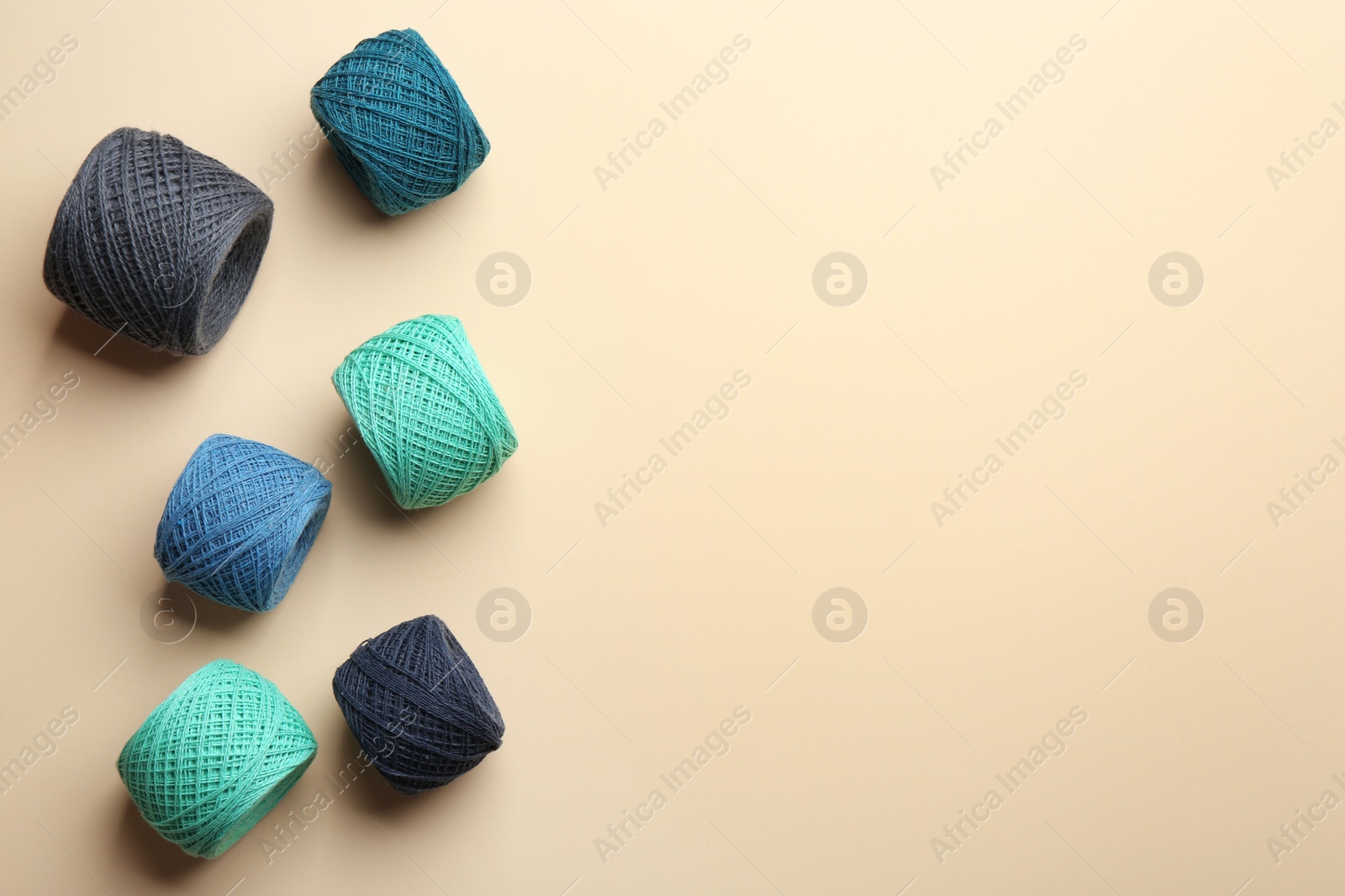 Photo of Clews of knitting threads on color background, flat lay with space for text. Sewing stuff