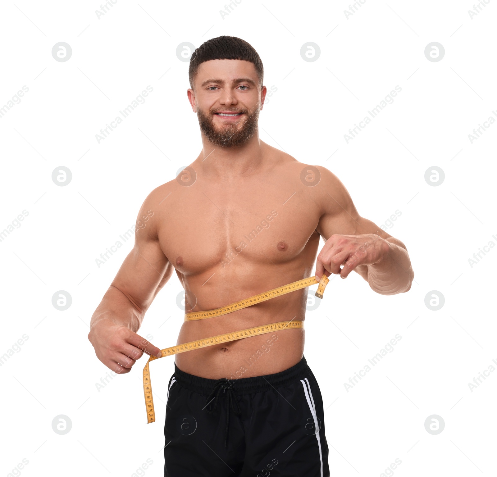 Photo of Happy athletic man measuring waist with tape on white background. Weight loss concept