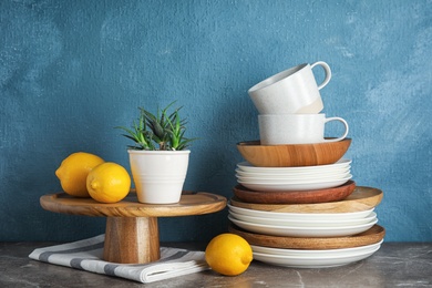 Composition with dinnerware on table against color background. Interior element