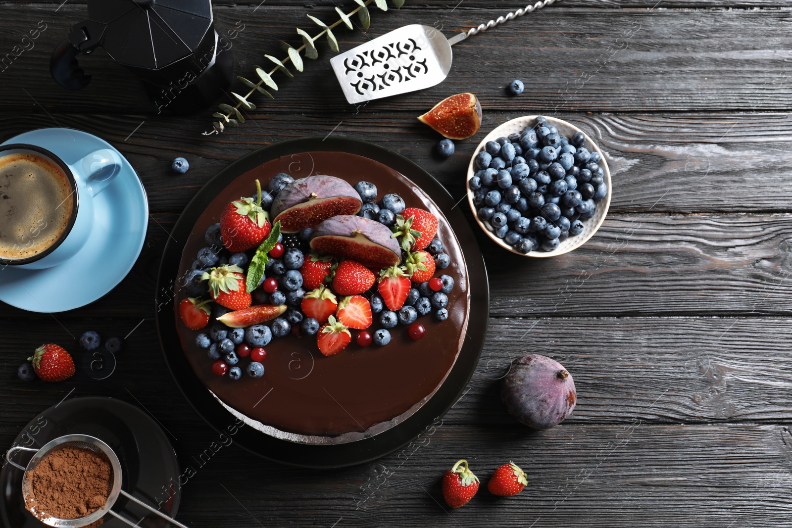 Photo of Fresh delicious homemade chocolate cake with berries on dark table, flat lay