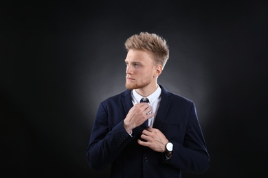 Portrait of handsome young businessman on dark background