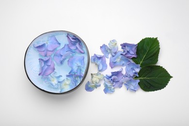 Photo of Spa composition. Aromatic water in bowl, flowers and leaves on white background, flat lay