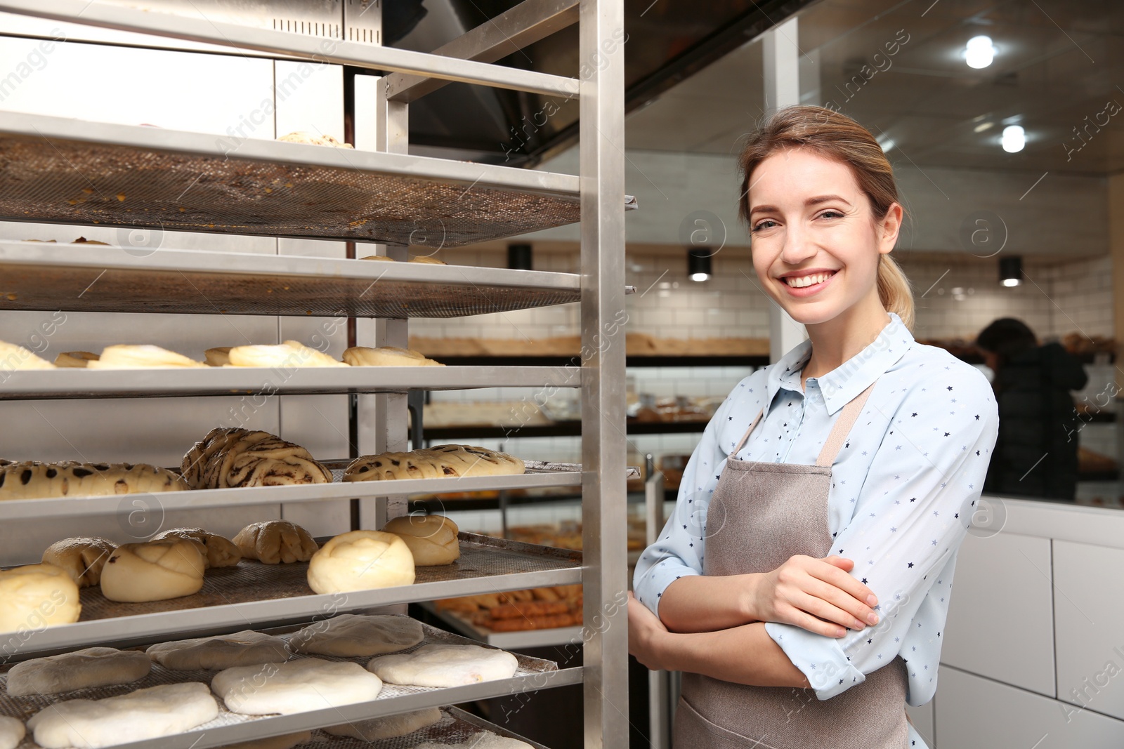 Photo of Baker at rack with pastries in workshop