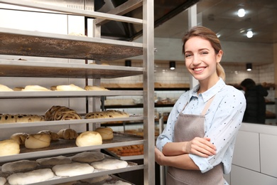 Baker at rack with pastries in workshop