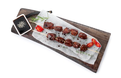 Photo of Skewers with pieces of tasty chicken meat glazed in soy sauce, herbs and cut chili pepper isolated on white, top view