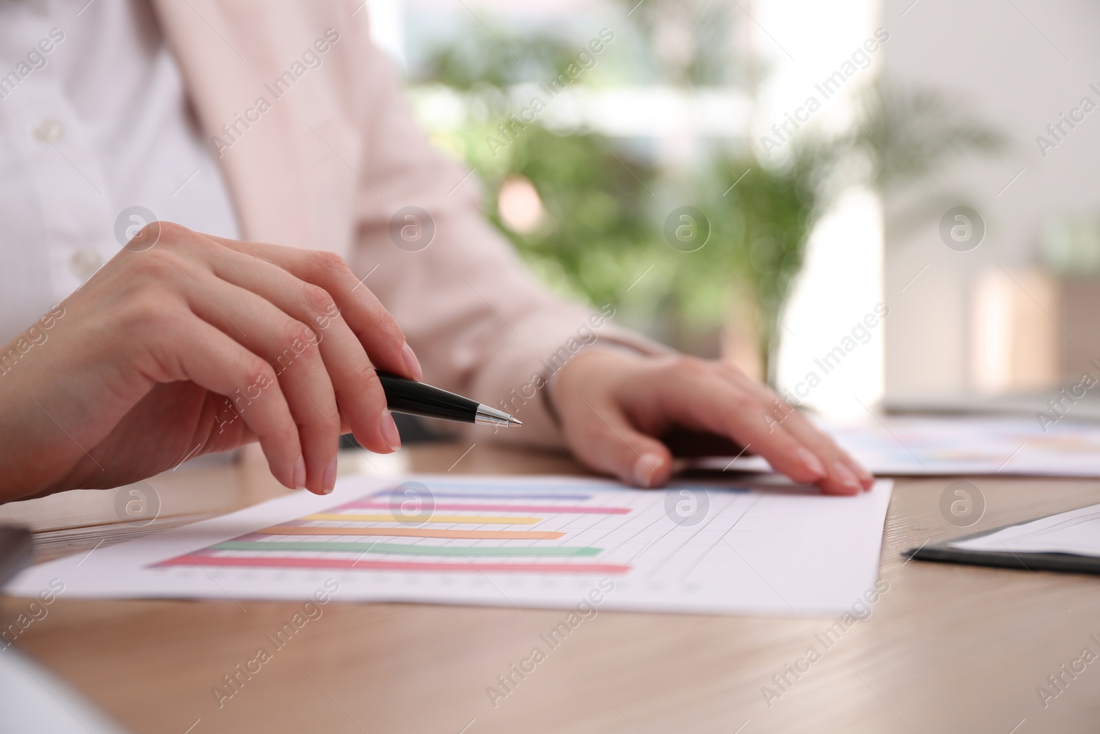 Photo of Businesswoman working with charts and graphs at table in office, closeup. Investment analysis