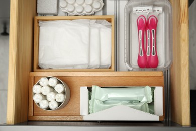 Photo of Storage of different feminine hygiene products in wooden drawer, top view