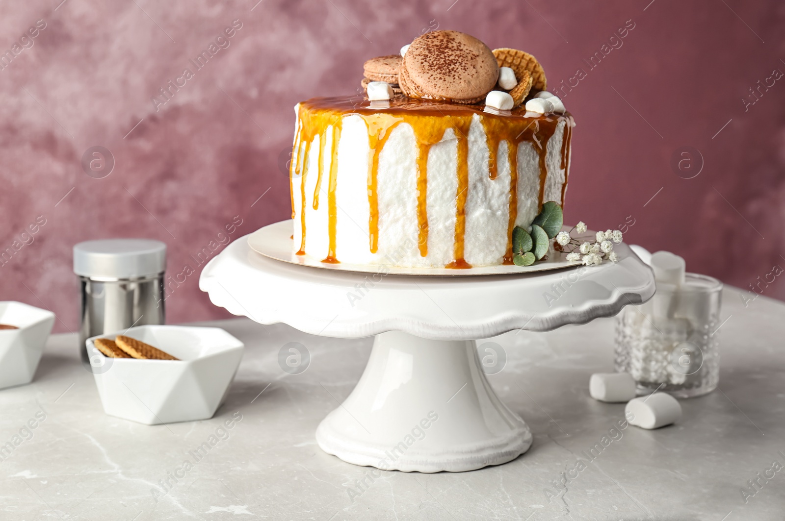 Photo of Dessert stand with delicious caramel cake on table