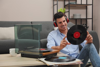 Happy man listening to music with turntable at home