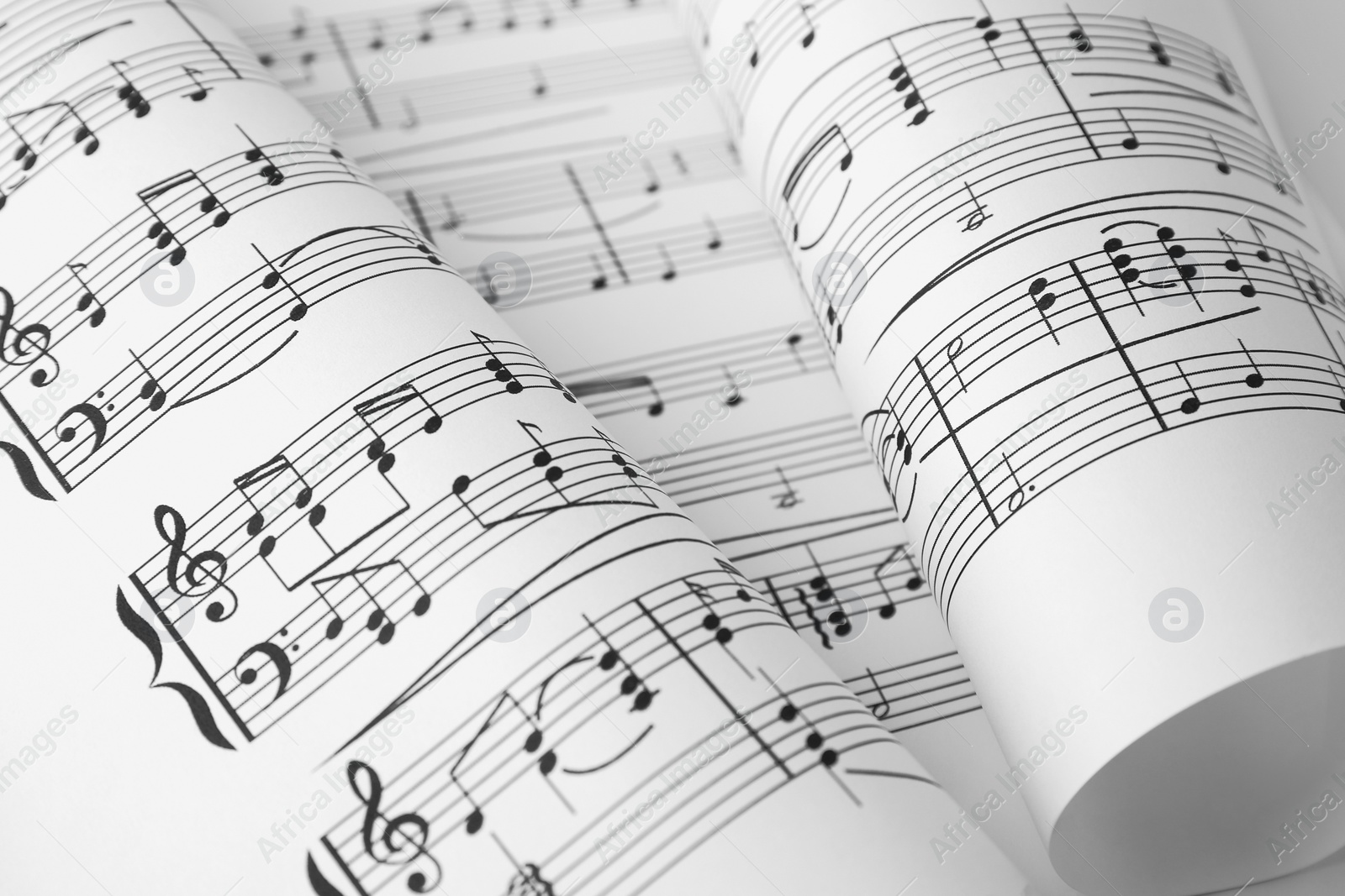 Photo of Sheets of paper with music notes as background, closeup view