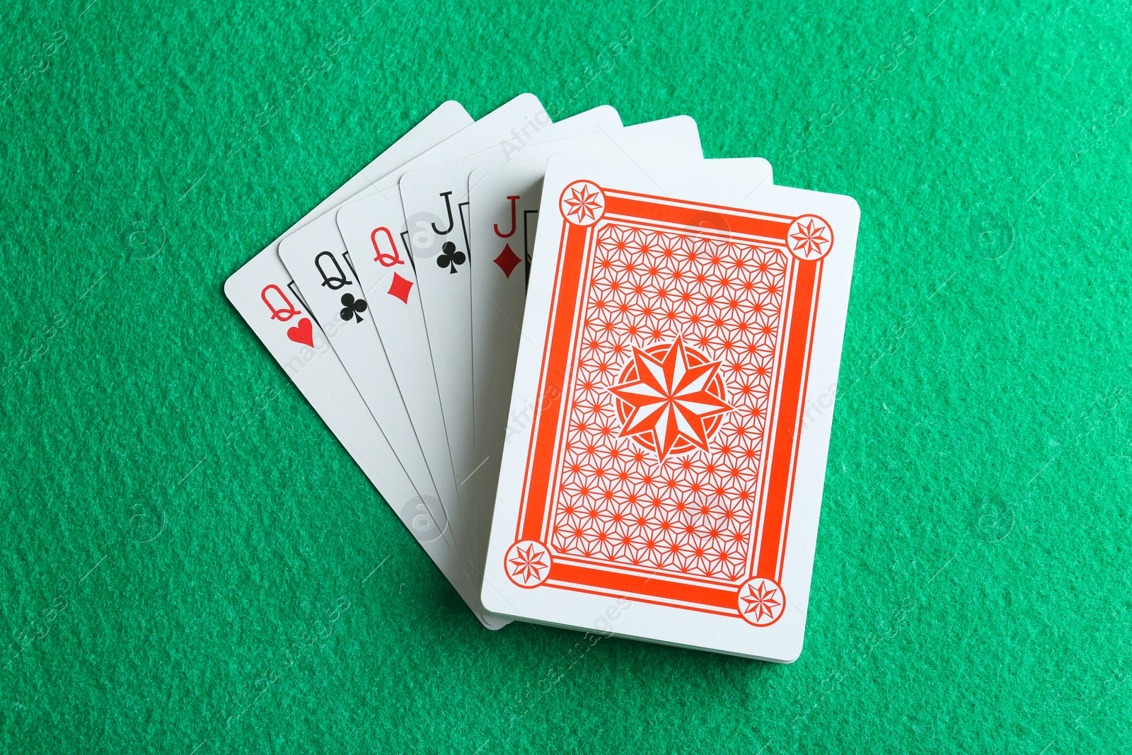 Photo of Playing cards with full house combination on green table, top view