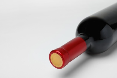 Photo of Bottle of expensive red wine on light background