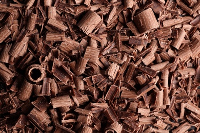 Photo of Pile of tasty chocolate curls as background, top view