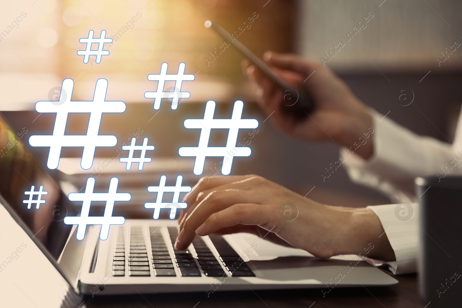 Image of Woman using modern laptop and smartphone at table, closeup. Hashtag symbols over device