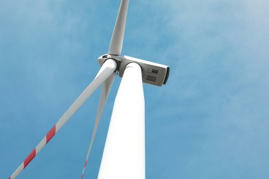 Modern wind turbine against blue sky, low angle view. Alternative energy source