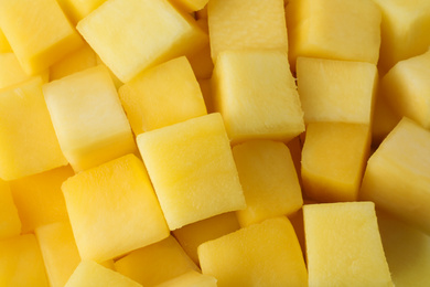 Many delicious mango cubes as background, closeup