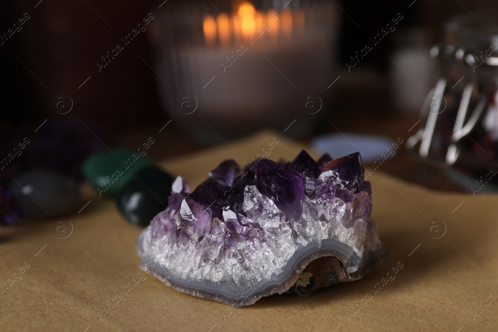 Photo of Composition with healing amethyst gemstone on table, closeup