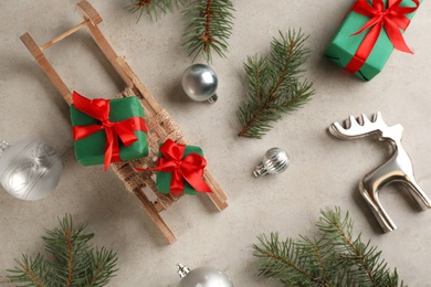 Beautiful Christmas composition with miniature sleigh on light table, flat lay