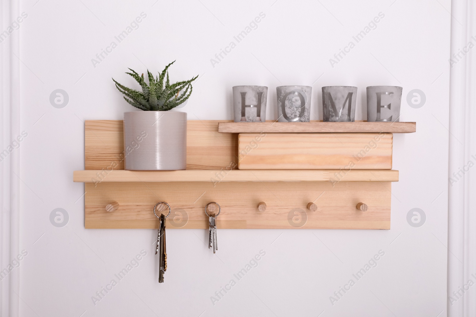 Photo of Wooden hanger for keys with decor on white wall