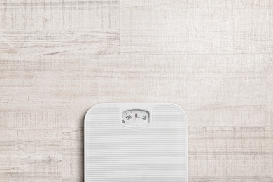 Photo of Bathroom scales and space for text on wooden background, top view. Weight loss concept