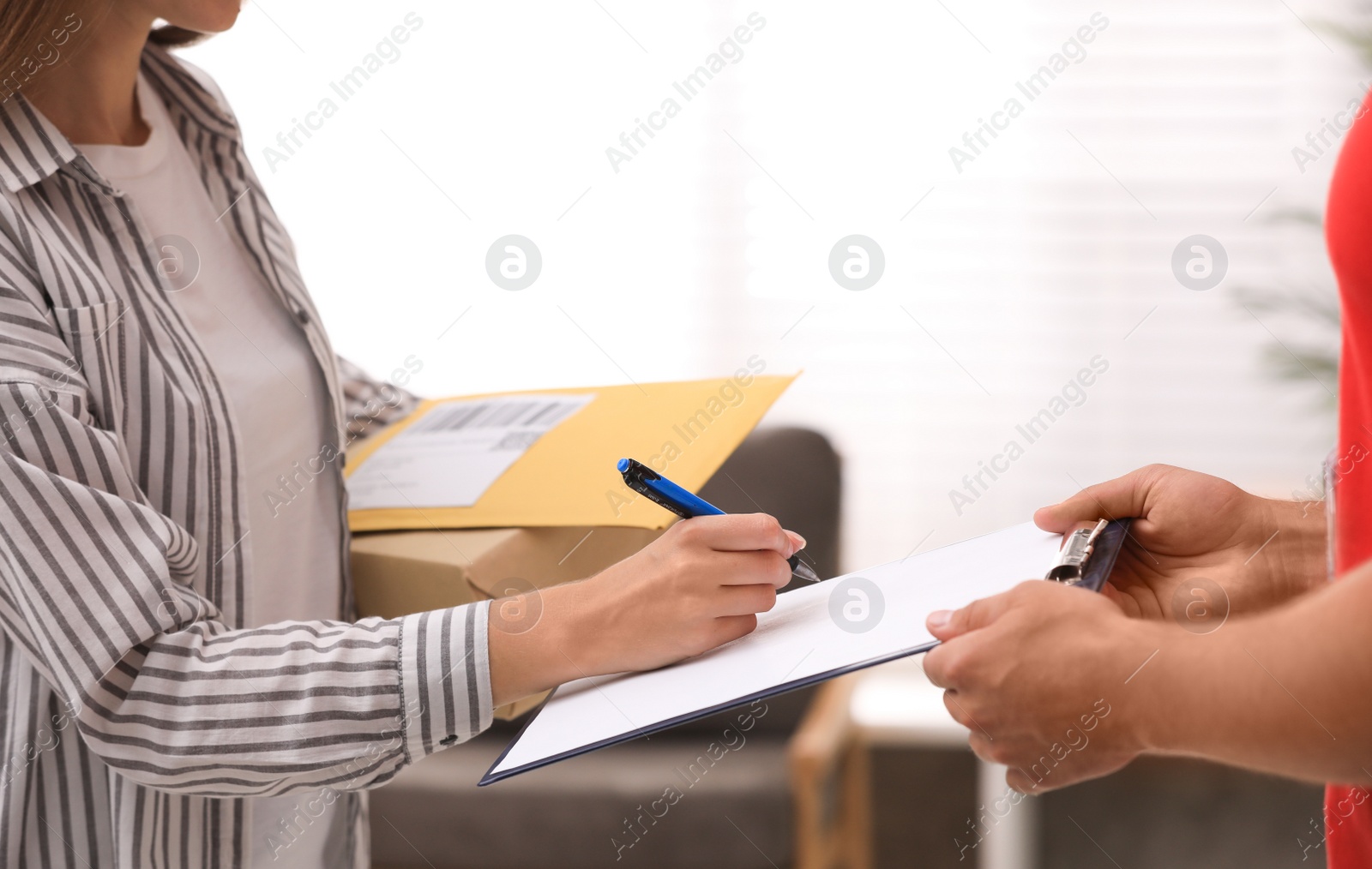 Photo of Woman signing for delivered parcels at home, closeup. Courier service