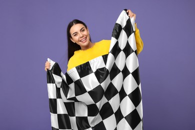 Photo of Happy young woman with checkered flag on violet background