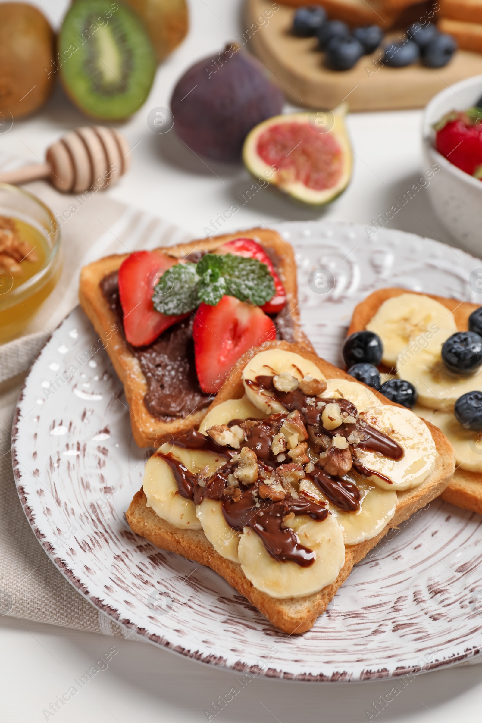 Photo of Different sweet delicious toasts on plate, closeup