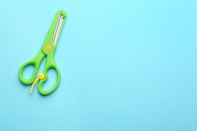 Training scissors on color background, top view. Space for text