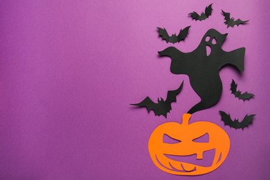 Flat lay composition with paper ghost, spooky pumpkin and bats on purple background, space for text. Halloween celebration