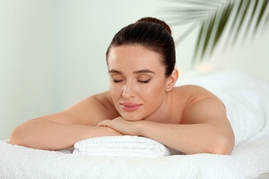 Photo of Beautiful young woman relaxing in spa salon