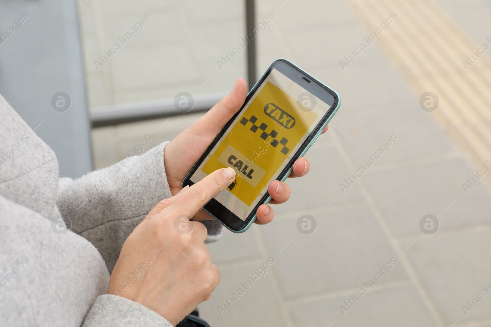 Photo of Woman ordering taxi with app on her smartphone outdoors, closeup