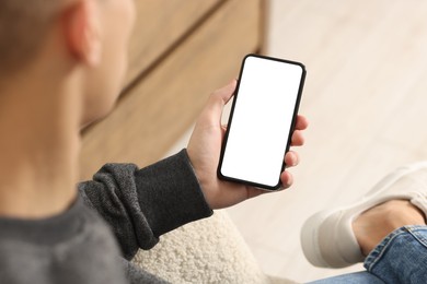 Photo of Man using smartphone with blank screen indoors, closeup. Mockup for design