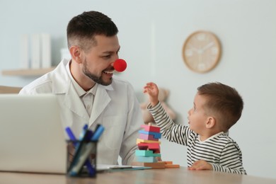 Photo of Pediatrician playing with little boy at hospital