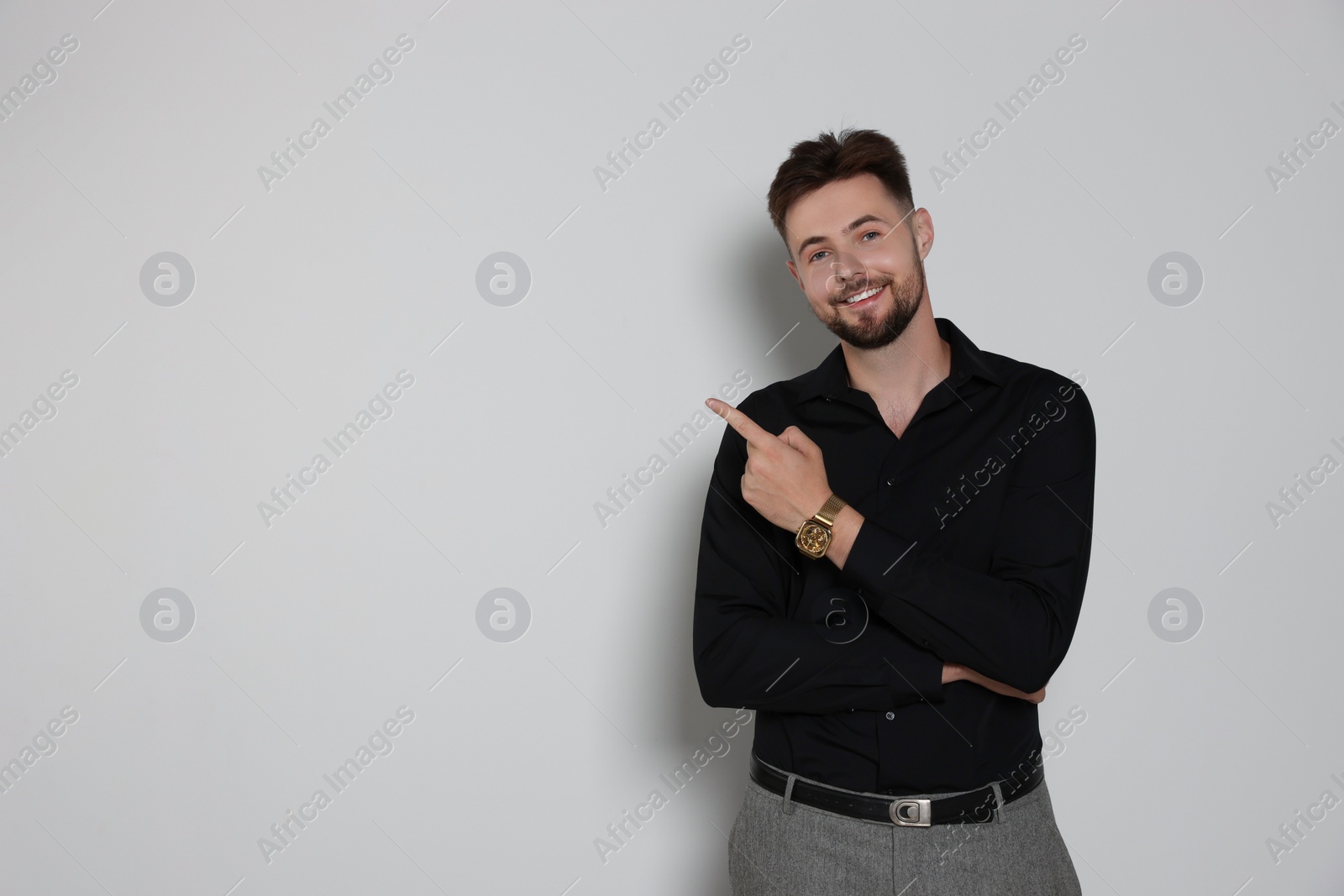 Photo of Handsome man in black shirt on light grey background, space for text