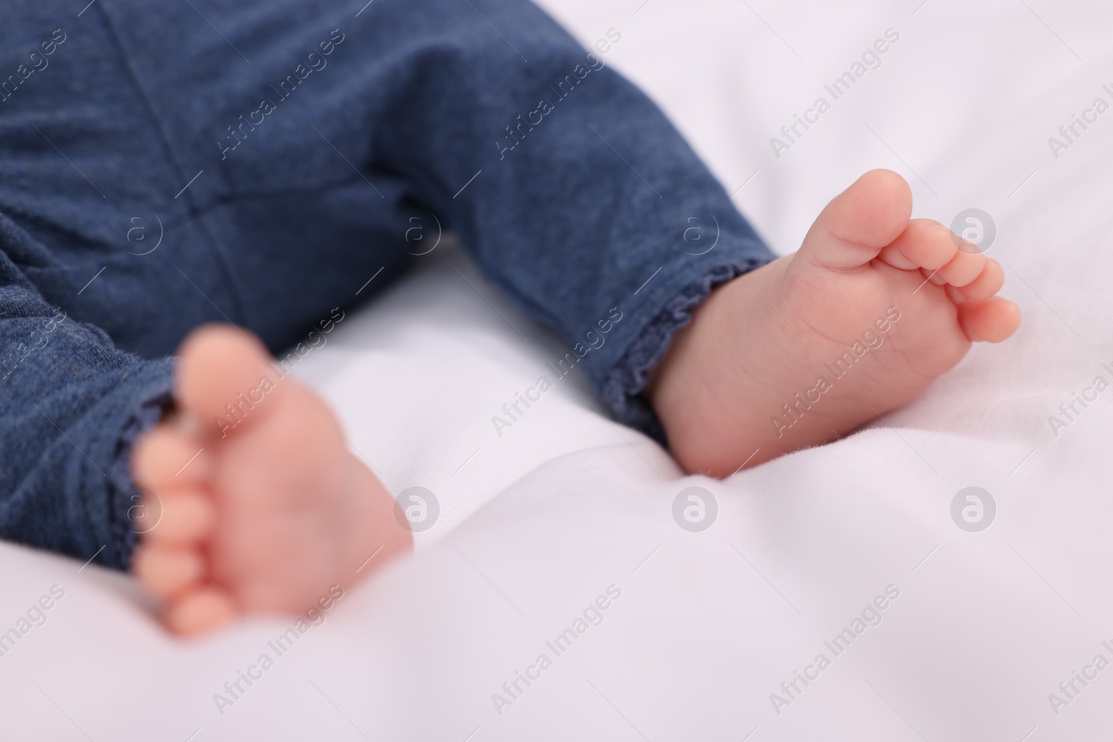 Photo of Newborn baby lying on white blanket, closeup